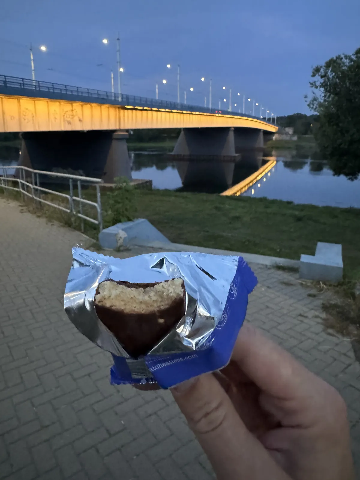 Atplėštas Cheatless batonėlis vakare prie tilto
